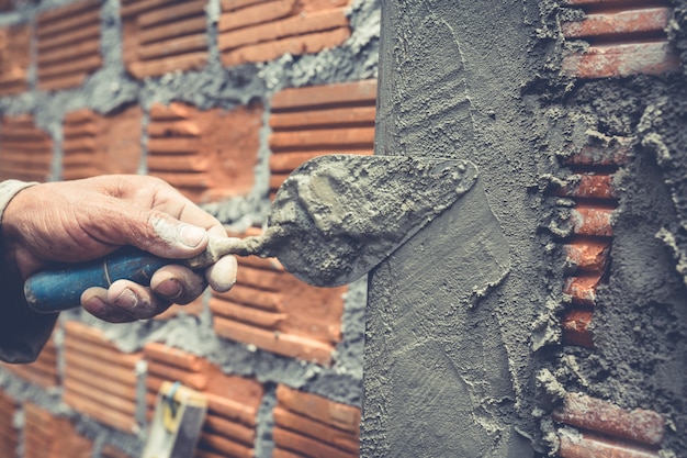 Bricklaying. construction worker building a brick wall. Free Photo