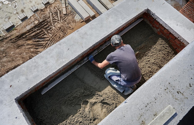 Male worker screeding floor at construction site Free Photo