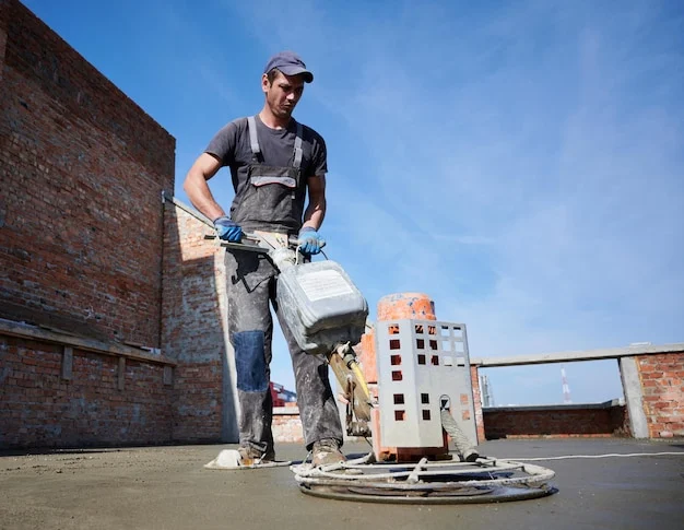 Worker using power trowel machine at construction site Free Photo